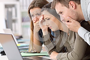 Worried employees reading bad news on line photo