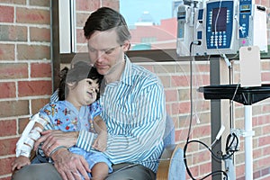 Worried father holding child in Hospital