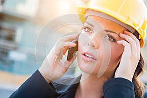 Worried Female Contractor Wearing Hard Hat on Site Using Cell Ph