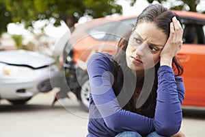 Worried Female Driver Sitting By Car After Traffic Accident