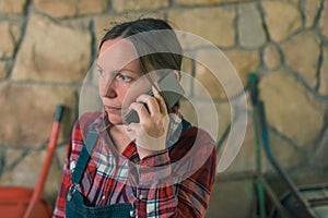 Worried female farmer talking on mobile phone