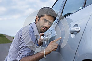 Worried funny looking man obsessing about cleanliness of his car