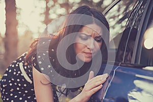 Worried funny looking woman obsessing about cleanliness of her car