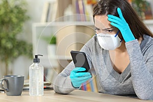 Worried girl with gloves reads covid-19 news on phone at home