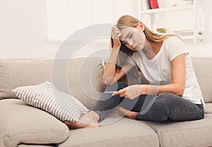 Worried girl reading results of her pregnancy test