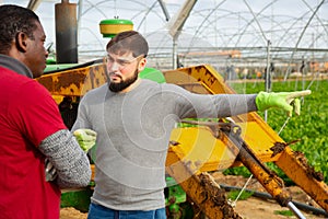 Worried grower talking to African American friend