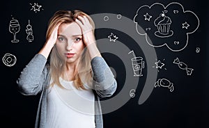 Worried hungry woman touching her head while being on a diet