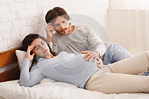 Worried husband touching belly of his pregnant wife that feeling unwell