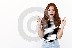 Worried intense embarrassed redhead woman in striped t-shirt gasping ambushed, looking alarmed and worried, anxiously