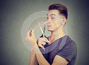 Worried liar man wants to cut his long nose photo