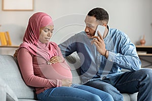 Worried Man Calling Doctor While His Pregnant Muslim Wife Suffering Prenatal Contractions