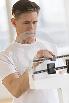 Worried Man Checking His Weight On Balance Scale