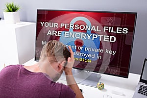 Worried Man At Computer With Ransomware On The Screen