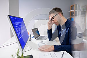 Worried Man At Computer With System Failure On The Screen