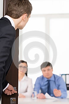 Worried man entering a room for job interview.