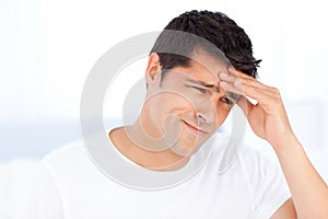 Worried man having a headache in his bedroom