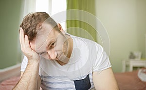 Worried man in his bedroom thinking about problems