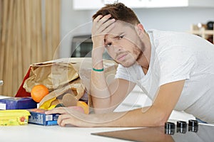 Worried man looking at bills in kitchen