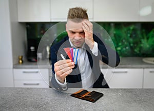 Worried man looking at his credit cards
