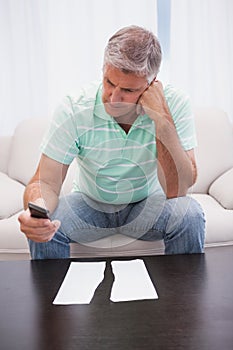 Worried man looking at ripped page sending a text