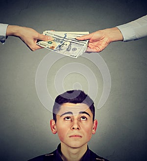 Worried man looking up at hands exchanging money