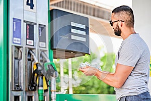 Worried man shocked how much gasoline costs.