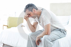 Worried man sitting on bed