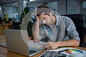 Worried man sitting with laptop at desk