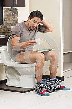 Worried man sitting on the toilet running out of