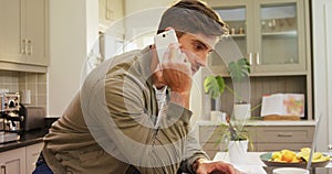 Worried man talking on phone while using his laptop 4K 4k