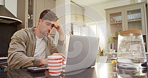 Worried man using his calculator while working on laptop 4K 4k