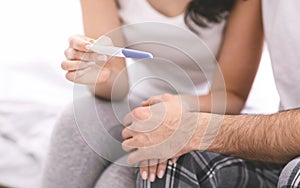 Worried man and woman waiting for result of pregnancy test