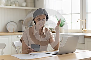 Worried mature homeowner woman counting expenses on calculator