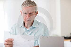 Worried Mature Man With Laptop Calculating Household Finances