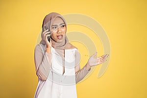 worried muslim woman in hijab making a call using a cell phone