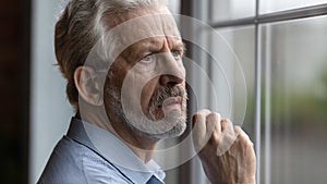 Worried nervous elderly man look at window wait for someone