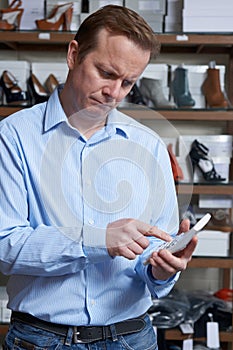 Worried Owner Of Shoe Store With Calculator