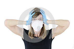 Worried person with virus protection surgical face mask and gloves holding her head in panic.
