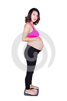 Worried pregnant woman standing on scale isolated on white