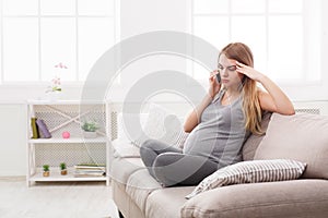 Worried pregnant woman talking on phone