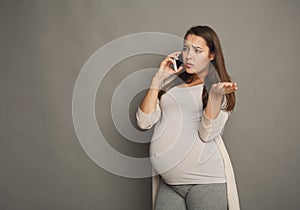 Worried pregnant woman talking on phone copy space