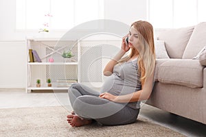 Worried pregnant woman talking on phone copy space