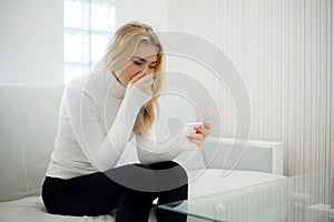 Worried sad woman Looking at a Pregnancy Test after result.