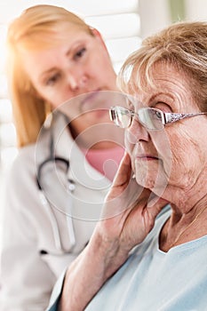 Worried Senior Adult Woman Being Consoled by Female Doctor or Nurse