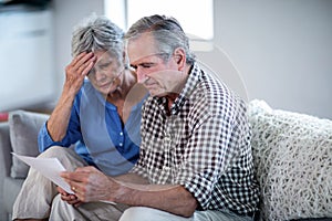 Worried senior couple checking the bills