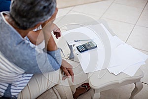 Worried senior couple checking bills in living room