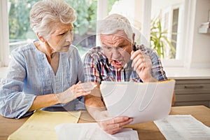 Worried senior couple checking their bills