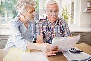 Worried senior couple checking their bills