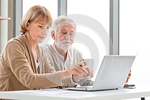 Worried senior couple checking their bills, retired elderly old family reading documents