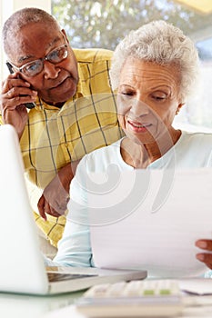 Worried Senior Couple Using Laptop At Home